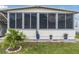 Charming home exterior featuring large windows and a meticulously landscaped yard with decorative potted plants at 170 Edgewood Dr, Osprey, FL 34229