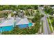 Aerial view of a bright blue house with a private pool, lush landscaping, and a nearby street at 202 75Th St, Holmes Beach, FL 34217