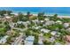 A beautiful aerial view of homes near a pristine beach, surrounded by lush trees and clear blue water at 202 75Th St, Holmes Beach, FL 34217