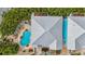 Overhead view of a coastal home featuring a swimming pool, metal roof, and lush tropical landscaping at 202 75Th St, Holmes Beach, FL 34217