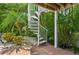 Backyard includes a spiral staircase surrounded by tropical landscaping at 202 75Th St, Holmes Beach, FL 34217