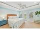 This coastal bedroom offers natural light, tray ceilings, a ceiling fan and a lovely view from the door at 202 75Th St, Holmes Beach, FL 34217