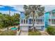 Beautiful exterior view of a beach house with a private pool and balcony overlooking tropical landscaping at 202 75Th St, Holmes Beach, FL 34217