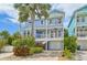 Charming blue two-story beach house with a brick driveway and tropical landscaping at 202 75Th St, Holmes Beach, FL 34217