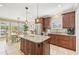 Spacious kitchen featuring dark cabinetry, a granite island, stainless steel appliances, and adjacent dining area at 202 75Th St, Holmes Beach, FL 34217