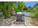 Outdoor grill on brick patio surrounded by tropical landscaping, ready for backyard barbecues at 202 75Th St, Holmes Beach, FL 34217