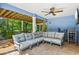 Covered patio has cozy seating, a ceiling fan, and an entertainment center at 202 75Th St, Holmes Beach, FL 34217