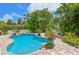 A private backyard pool surrounded by tropical foliage and a brick patio for relaxation at 202 75Th St, Holmes Beach, FL 34217