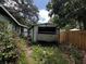 Shows a detached garage with an opening and a fenced in area near the overgrown yard at 2026 Seminole S Blvd, St Petersburg, FL 33705