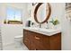 Bathroom with a wood vanity, a round mirror, and white hexagonal floor tiles at 2460 Hillview St, Sarasota, FL 34239