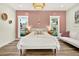 Bright bedroom featuring a textured pink accent wall, white furniture, and sun-filled windows at 2460 Hillview St, Sarasota, FL 34239