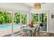 Bright dining room with natural light and views of lush greenery and pool through sliding glass doors at 2460 Hillview St, Sarasota, FL 34239