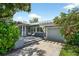 Gray brick house with lush landscaping and a paved parking area with garage at 2460 Hillview St, Sarasota, FL 34239