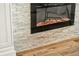 Close up of modern electric fireplace with white brick and laminate flooring at 2460 Hillview St, Sarasota, FL 34239