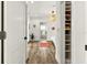 Bright hallway featuring wood floors, a decorative rug, and a view into a modern bathroom with a standalone tub at 2460 Hillview St, Sarasota, FL 34239