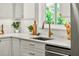 Close up of modern kitchen featuring white cabinets, stainless steel appliances, and bronze colored hardware at 2460 Hillview St, Sarasota, FL 34239