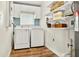 Efficient laundry room with modern appliances, blue tile backsplash, and plenty of storage shelves at 2460 Hillview St, Sarasota, FL 34239