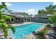 Backyard pool with patio area, sun shelf, tropical plants, and a nearby outdoor seating space at 2460 Hillview St, Sarasota, FL 34239