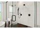 Sleek shower featuring a glass door and black fixtures set against white tiled walls at 2460 Hillview St, Sarasota, FL 34239