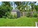 Backyard storage shed surrounded by lush landscaping and greenery at 2460 Hillview St, Sarasota, FL 34239