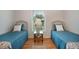 Bedroom featuring two twin beds, ceiling fan, hardwood floors, and a window with bright light at 2710 93Rd E Ct, Palmetto, FL 34221