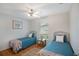 Cozy bedroom featuring two twin beds, ceiling fan, hardwood floors, and a window with bright light at 2710 93Rd E Ct, Palmetto, FL 34221