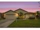 Charming single-story home featuring a well-manicured lawn, lush landscaping, and an attached two-car garage at 2710 93Rd E Ct, Palmetto, FL 34221