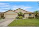 Charming single-story home featuring a well-manicured lawn, lush landscaping, and an attached two-car garage at 2710 93Rd E Ct, Palmetto, FL 34221
