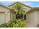 Inviting front entrance is surrounded by lush landscaping and adorned with vibrant plants and a decorative welcome mat at 2710 93Rd E Ct, Palmetto, FL 34221