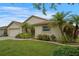 A beautiful, well-kept front yard with green grass, colorful flowers, and a variety of lush plants and palm trees at 2710 93Rd E Ct, Palmetto, FL 34221