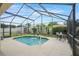 A pristine pool with a fountain feature, surrounded by palm trees and a lush, fenced-in backyard at 2710 93Rd E Ct, Palmetto, FL 34221