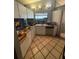 Compact kitchen featuring white cabinets, tile floor, and essential appliances at 303 70Th Nw St, Bradenton, FL 34209
