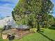 Backyard with a small wooden deck, potted plants, and mature tree providing shade at 3324 Laurel Oak Way, Sarasota, FL 34237