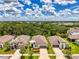 Aerial shot of homes with lush green landscaping under a partly cloudy blue sky at 3602 Secret Stroll Dr, Sarasota, FL 34240