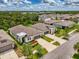 Aerial shot of homes with lush green landscaping under a partly cloudy blue sky at 3602 Secret Stroll Dr, Sarasota, FL 34240