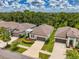 Aerial shot of homes with lush green landscaping under a partly cloudy blue sky at 3602 Secret Stroll Dr, Sarasota, FL 34240
