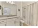 Well-lit bathroom with granite countertops, white cabinets, and a shower-tub combo with a white curtain at 3602 Secret Stroll Dr, Sarasota, FL 34240