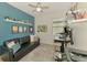 Stylish bedroom with a black sofa, and shelves decorated with plants and collectibles, bathed in natural light at 3602 Secret Stroll Dr, Sarasota, FL 34240