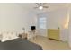 Neutral bedroom with a twin bed, desk, and dresser, illuminated by natural light and a modern lamp at 3602 Secret Stroll Dr, Sarasota, FL 34240