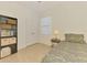 Simple bedroom features a patterned bed, a bookcase, neutral color scheme, and ample natural light at 3602 Secret Stroll Dr, Sarasota, FL 34240