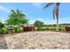 Outdoor community BBQ area with grills on a paver patio surrounded by lush landscaping and palm trees at 3602 Secret Stroll Dr, Sarasota, FL 34240