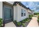 Inviting light teal front door with glass pane and storm door at 3602 Secret Stroll Dr, Sarasota, FL 34240
