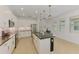 Modern kitchen with white cabinets, stainless steel appliances, granite countertops and view of the entry at 3602 Secret Stroll Dr, Sarasota, FL 34240