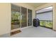 Screened-in lanai with view into house, sliding glass doors and covered grill at 3602 Secret Stroll Dr, Sarasota, FL 34240