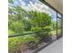 Screened-in lanai showing a view of lush landscaping and greenery at 3602 Secret Stroll Dr, Sarasota, FL 34240