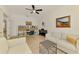 Open-concept living room with bookshelf, piano, and neutral furniture creating a welcoming and versatile space at 3602 Secret Stroll Dr, Sarasota, FL 34240