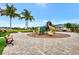 This ground-level view showcases the community playground with mature palm trees and plenty of green space at 3602 Secret Stroll Dr, Sarasota, FL 34240