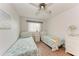 Bright bedroom featuring two twin beds with nautical-themed bedding, natural light, and a ceiling fan at 3905 34Th Avenue W Dr # 36, Bradenton, FL 34205