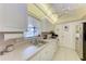 Well-lit kitchen features tile flooring, white cabinetry, and a double basin sink overlooking the yard at 3905 34Th Avenue W Dr # 36, Bradenton, FL 34205