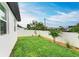 Well-maintained backyard with lush grass, a modern white fence, and thoughtfully designed landscaping at 4314 Des Plaines Dr, Sarasota, FL 34233